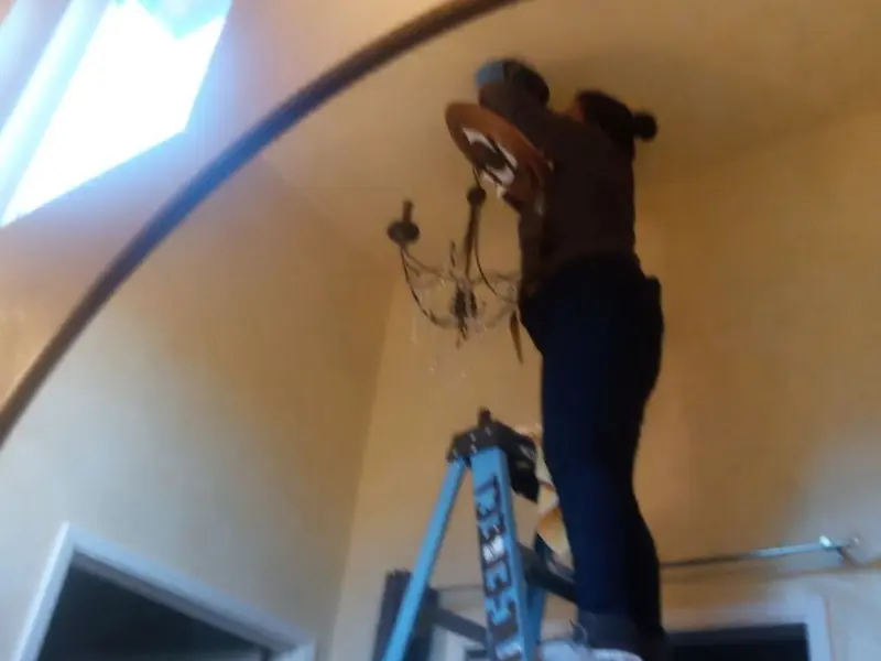 Electrician installing a chandelier in a Fircrest residence